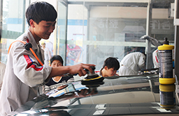 正在專注做汽車美容的學(xué)生。